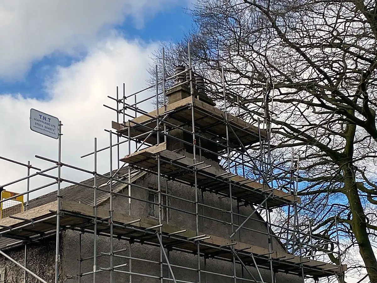 Chimney scaffold at roof level against a blue sky