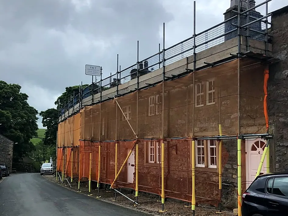Domestic scaffold with debris netting on a terraced street