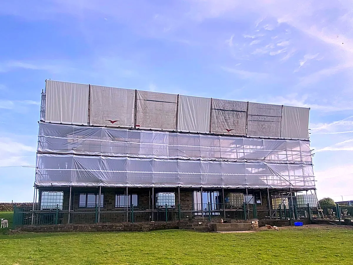Sheeted temporary roof system over a stone property